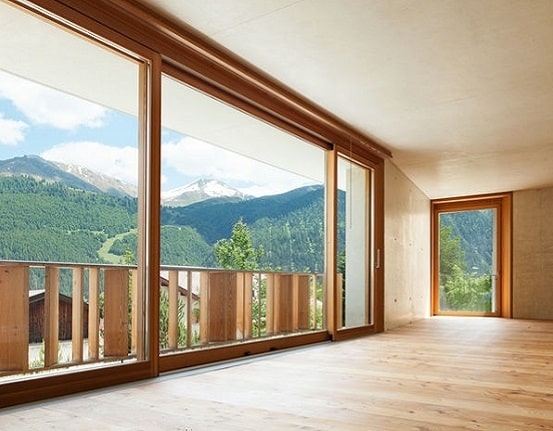 serramenti legno scorrevoli installati in una casa di design con una vista su pineta alberata