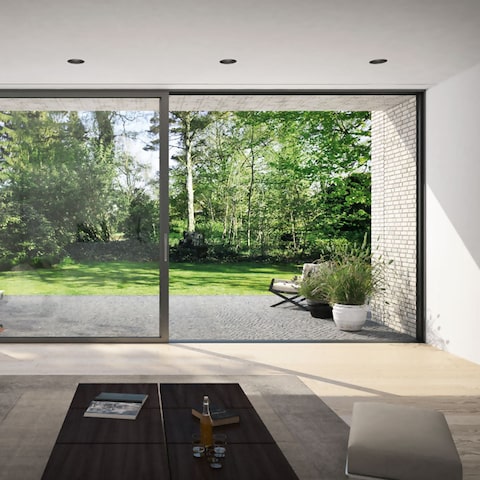 schuco panoramic sliding door installed in a modern house with garden view