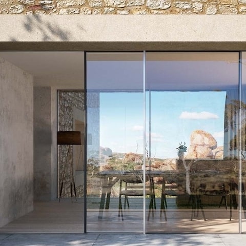 schuco panoramic sliding door installed in a renovated house with exposed stone wall